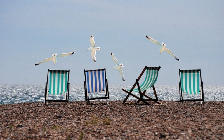 VACANZE NELL'ALTO JONIO COSENTINO sdraio sulla spiaggia di pietre con gabbiani che volano nel cielo